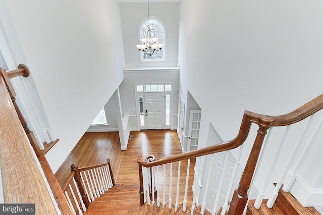 entryway featuring an inviting chandelier, stairway, a high ceiling, and wood finished floors