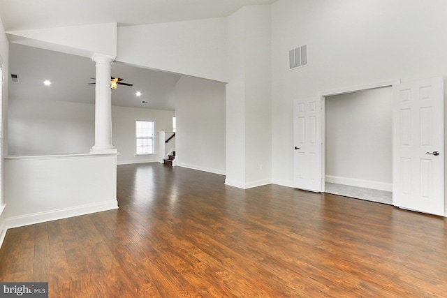 spare room with dark wood-style floors, decorative columns, visible vents, and a ceiling fan