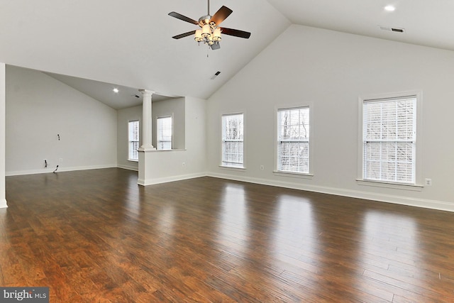 unfurnished living room with a healthy amount of sunlight, decorative columns, visible vents, and dark wood-type flooring