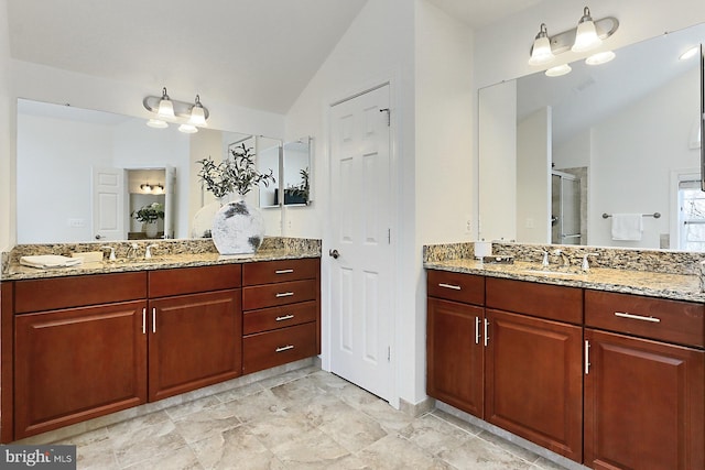 full bath featuring lofted ceiling, a stall shower, two vanities, and a sink