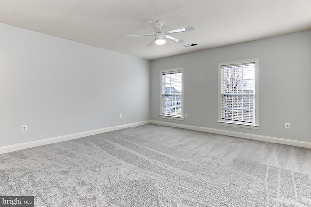 unfurnished room with ceiling fan, carpet, visible vents, and baseboards