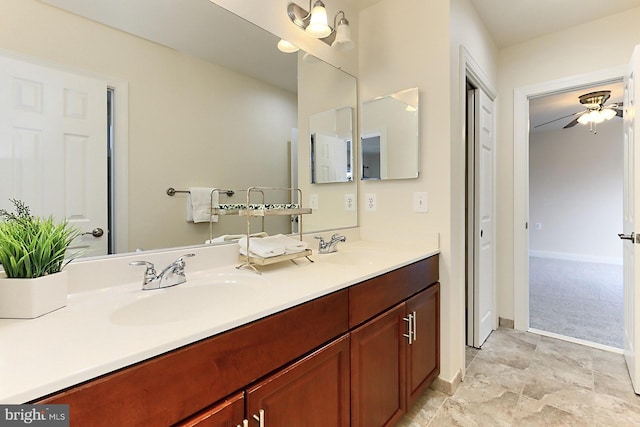 full bathroom with ceiling fan, a sink, baseboards, and double vanity