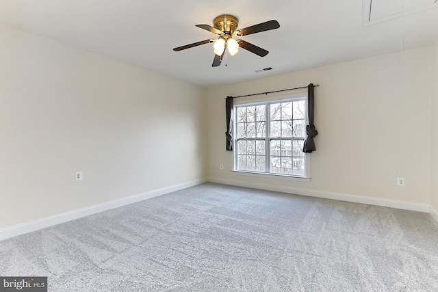 unfurnished room with light carpet, attic access, visible vents, baseboards, and ceiling fan