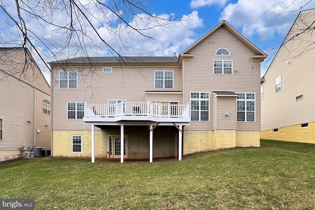 rear view of house with central AC unit, a deck, and a lawn