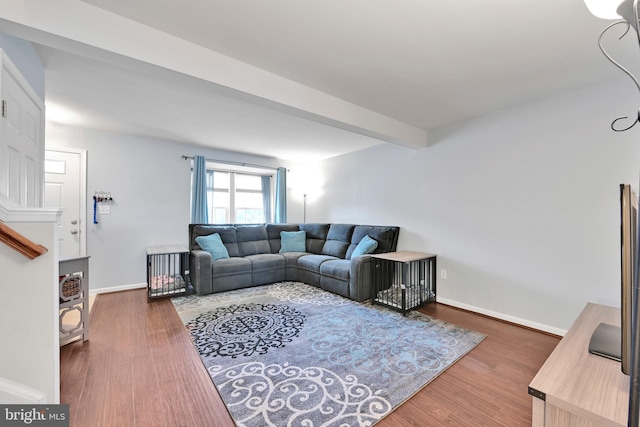 living area with beam ceiling, wood finished floors, and baseboards