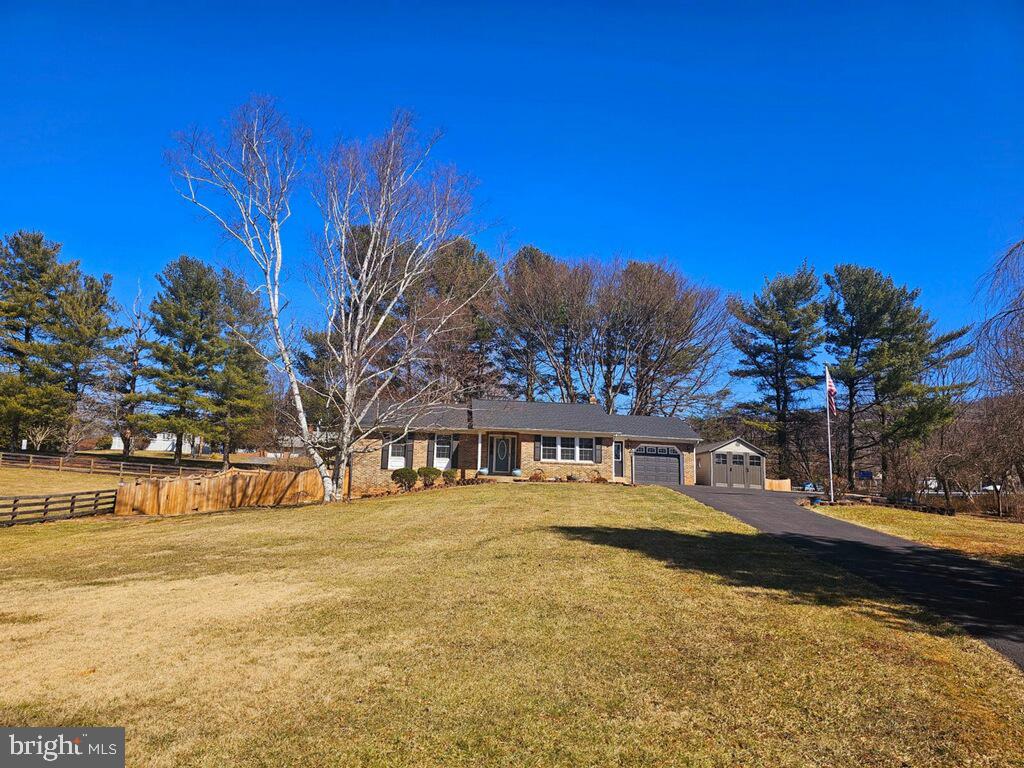 single story home featuring a garage, fence, and a front yard