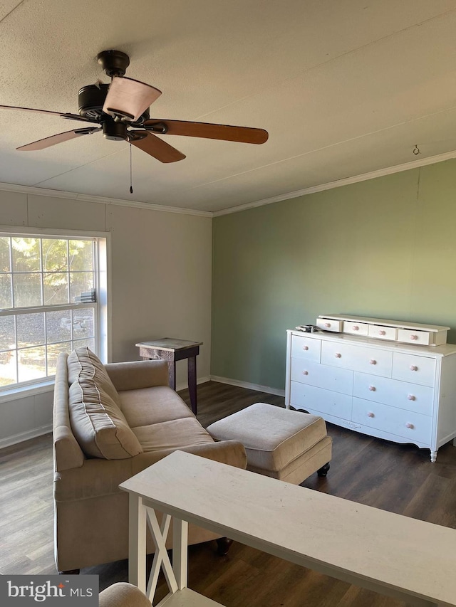 living area featuring a ceiling fan, baseboards, dark wood finished floors, and crown molding