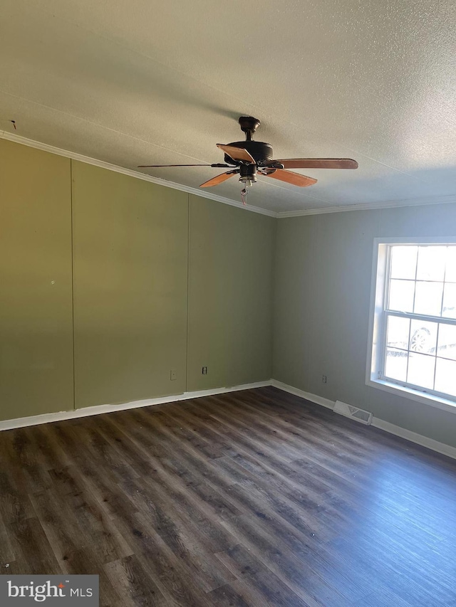 empty room with ornamental molding, dark wood-type flooring, and visible vents