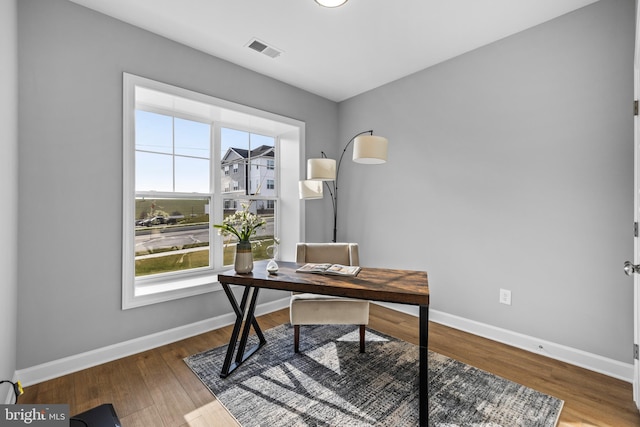 home office with visible vents, baseboards, and wood finished floors