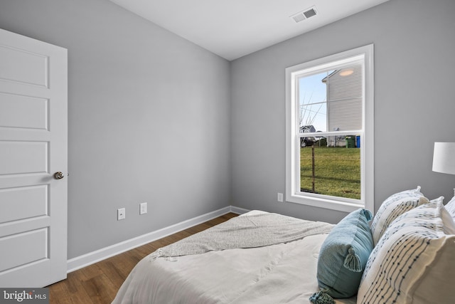 bedroom with dark wood-style flooring, visible vents, and baseboards