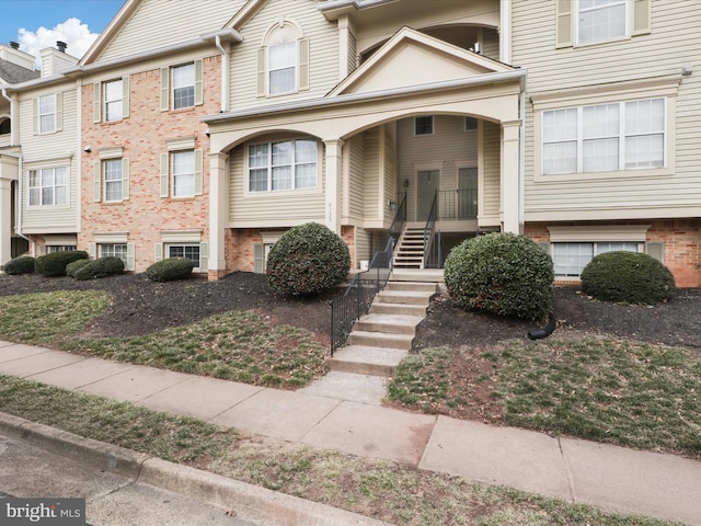 multi unit property featuring stairs and brick siding