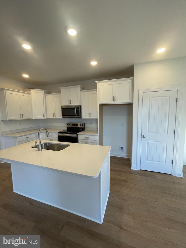 kitchen with recessed lighting, dark wood-type flooring, a sink, white cabinetry, and appliances with stainless steel finishes