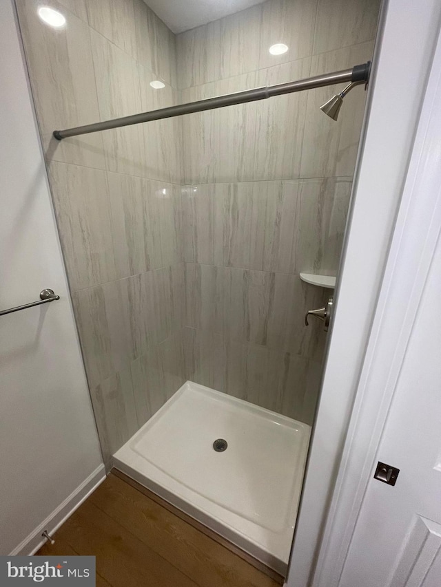 full bath featuring a shower stall and baseboards