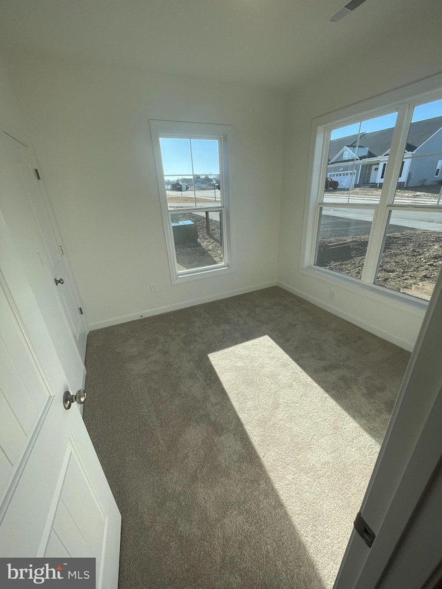 unfurnished room featuring baseboards and carpet flooring