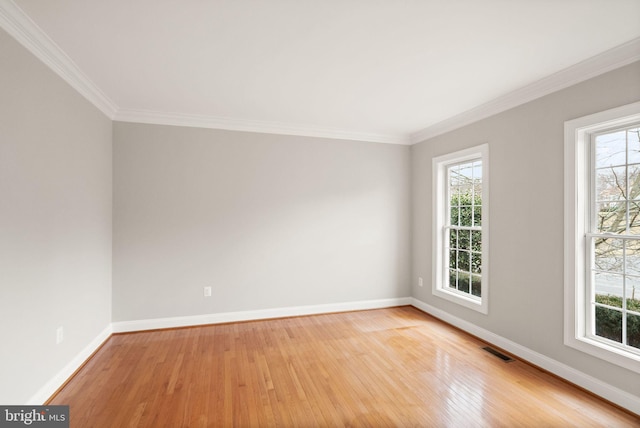 empty room with light wood-type flooring, baseboards, visible vents, and a wealth of natural light