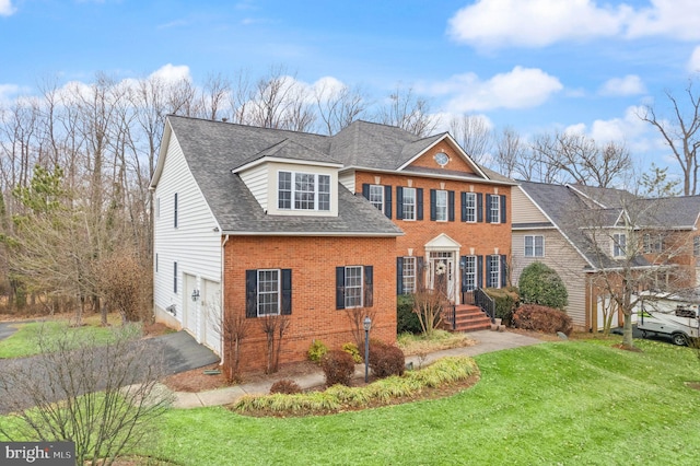 view of front of house with driveway, a garage, a shingled roof, brick siding, and a front yard