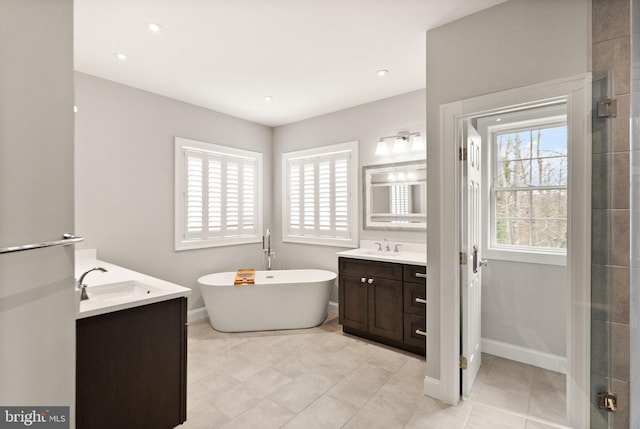 full bathroom with plenty of natural light, tiled shower, a freestanding bath, and vanity