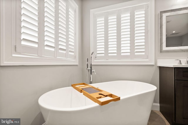 full bathroom with a freestanding bath and vanity