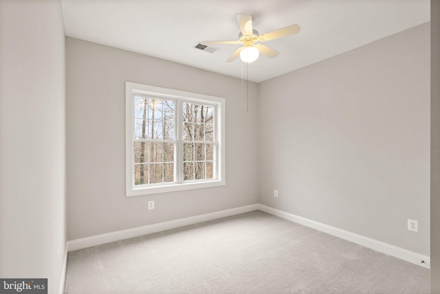 spare room with baseboards, visible vents, and light colored carpet