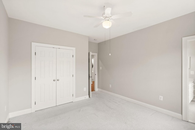 unfurnished bedroom with a closet, carpet flooring, ceiling fan, and baseboards