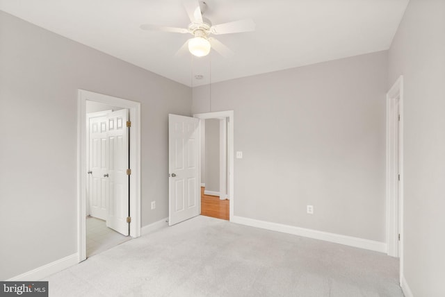 unfurnished bedroom featuring a ceiling fan, carpet, and baseboards