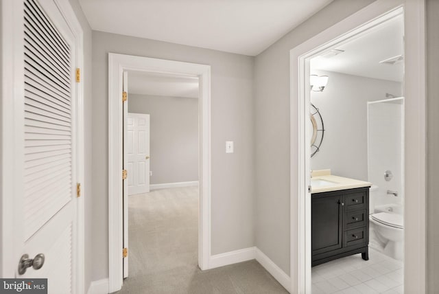 full bath featuring toilet, baseboards,  shower combination, and vanity