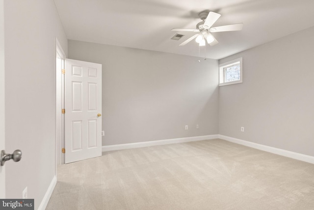 empty room featuring visible vents, ceiling fan, light carpet, and baseboards