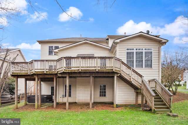 rear view of property with a hot tub, stairway, a deck, and a lawn