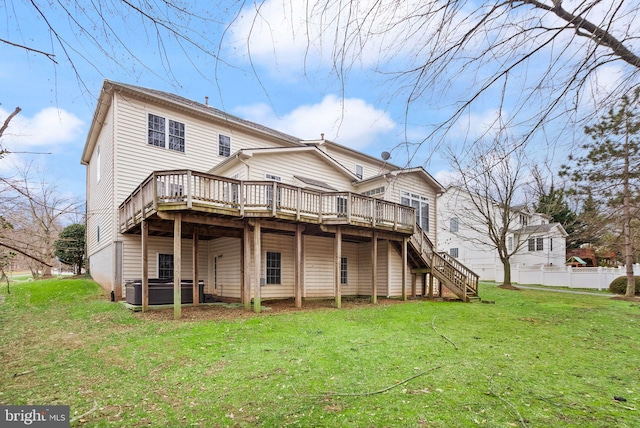 rear view of house featuring a yard, stairway, a wooden deck, and fence