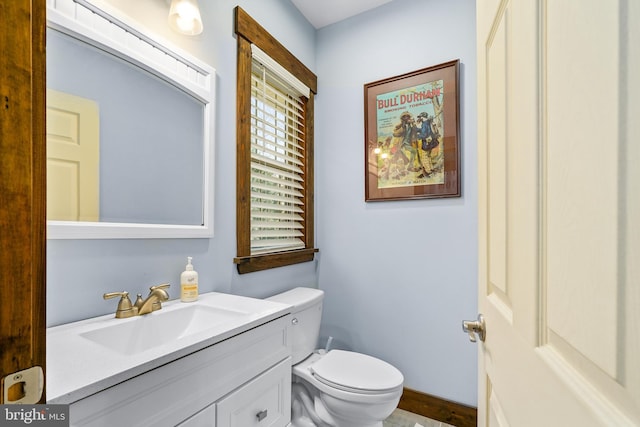 bathroom featuring vanity, toilet, and baseboards