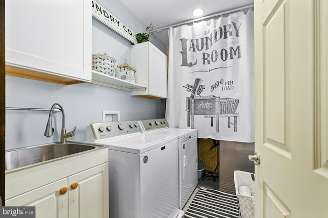 clothes washing area with cabinet space, washing machine and dryer, and a sink