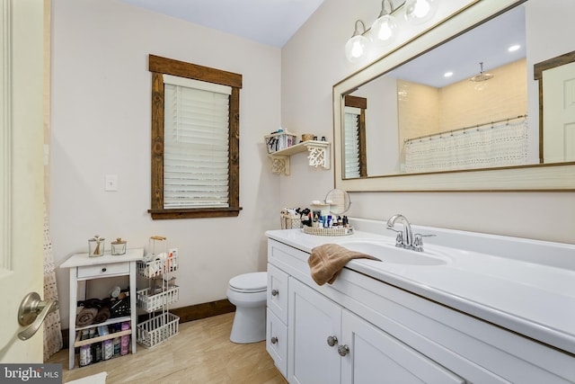 bathroom featuring toilet, curtained shower, baseboards, and vanity