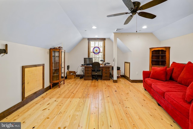 office space featuring wood-type flooring, visible vents, vaulted ceiling, ceiling fan, and baseboards