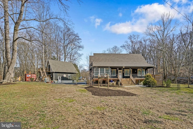 back of house with a porch, roof with shingles, and a lawn