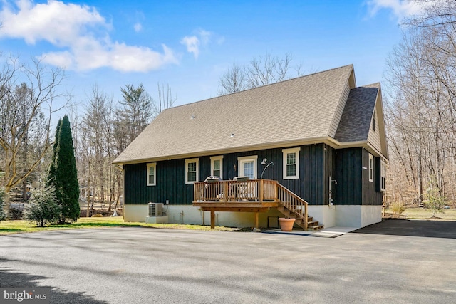 rustic home featuring roof with shingles