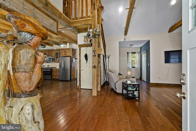 interior space with a high ceiling, dark wood-style flooring, beam ceiling, and baseboards