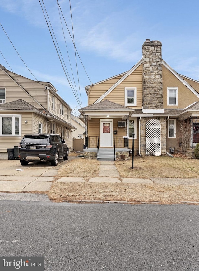 multi unit property featuring roof with shingles, a porch, and a chimney