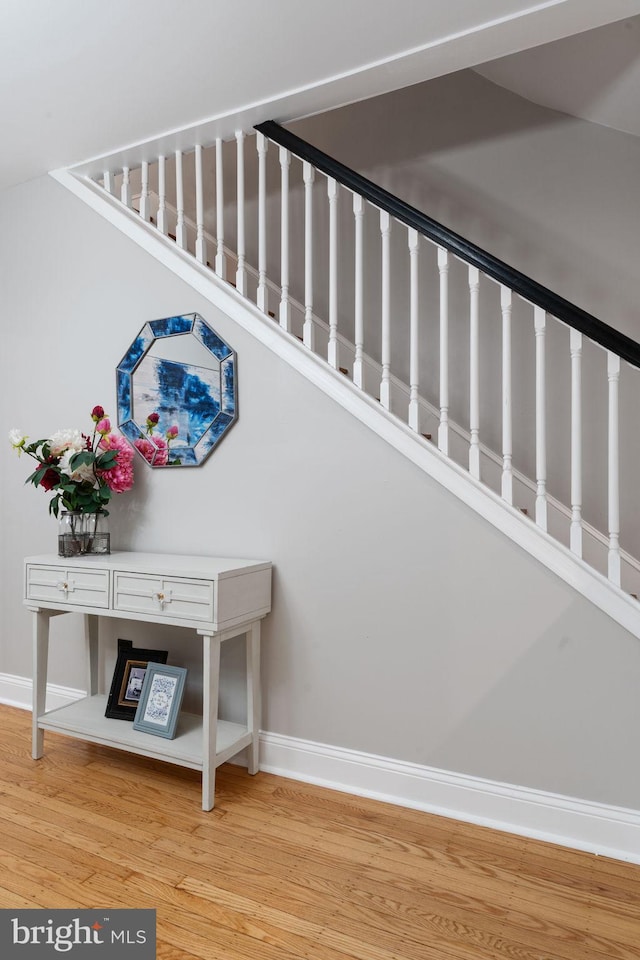 stairs featuring wood finished floors and baseboards