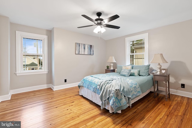 bedroom featuring light wood-type flooring, a ceiling fan, and baseboards