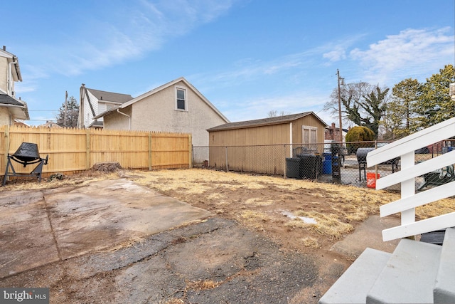 view of yard featuring a patio, an outdoor structure, and fence