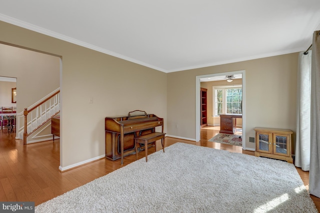 living area featuring crown molding, stairs, and hardwood / wood-style floors