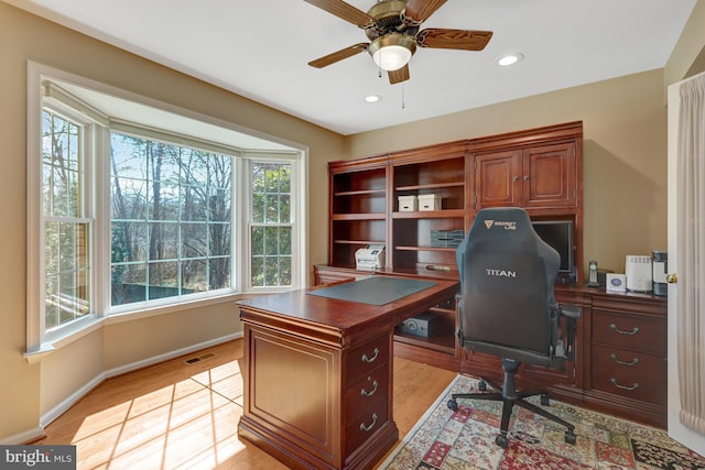 office with a ceiling fan, baseboards, visible vents, and light wood finished floors