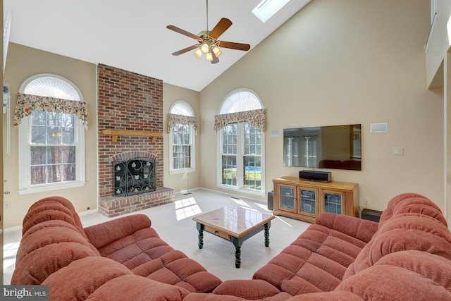 living area with a skylight, ceiling fan, carpet floors, a fireplace, and high vaulted ceiling