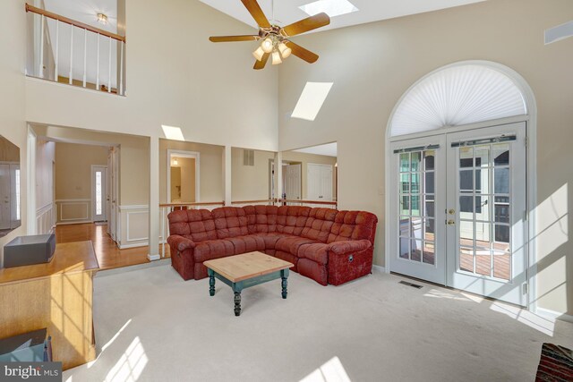 carpeted living room featuring a skylight, visible vents, a ceiling fan, and french doors