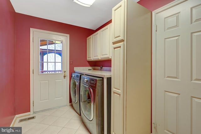 laundry area with cabinet space, light tile patterned floors, visible vents, baseboards, and washing machine and dryer