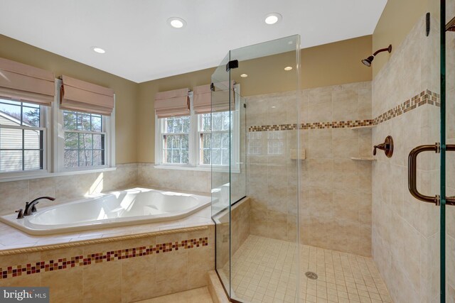 bathroom with recessed lighting, a garden tub, and a shower stall