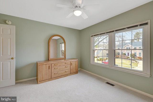 unfurnished bedroom with visible vents, light carpet, baseboards, and multiple windows