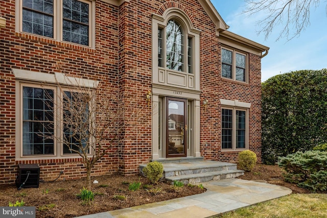 entrance to property featuring brick siding