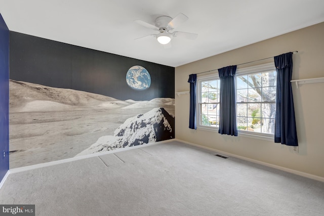 unfurnished bedroom featuring carpet floors, baseboards, visible vents, and a ceiling fan