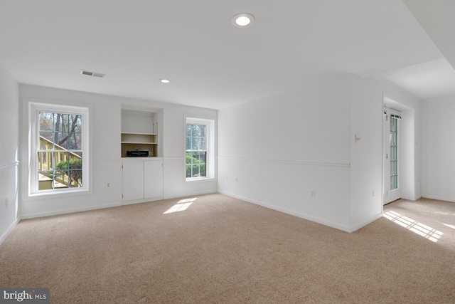 unfurnished living room featuring recessed lighting, baseboards, visible vents, and carpet flooring